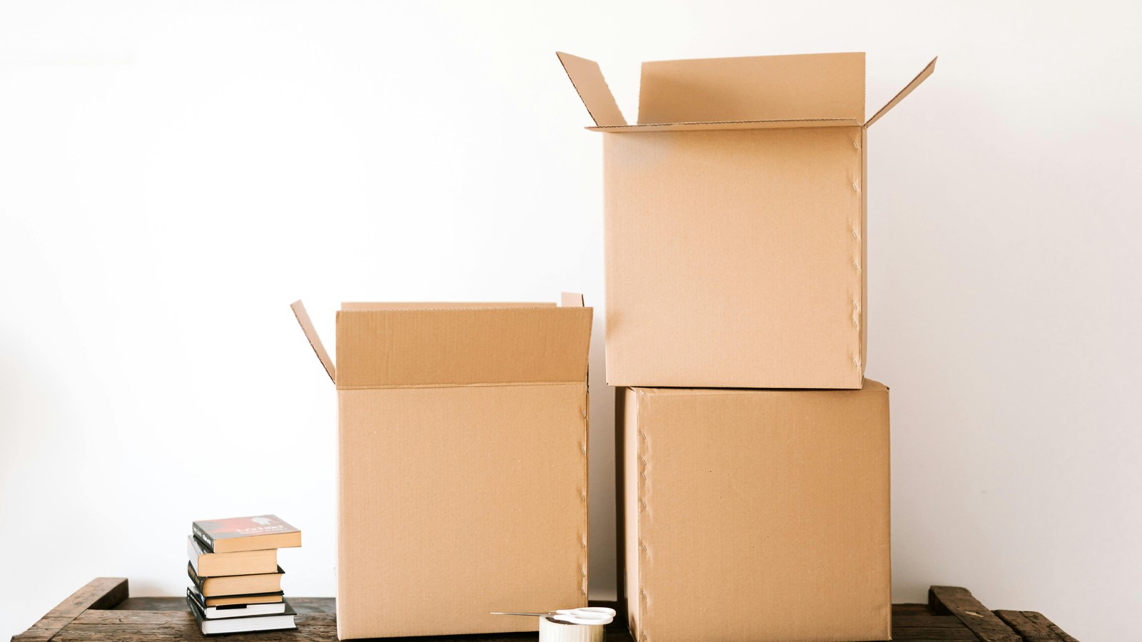 Stacked books beside cardboard shipping boxes for print quantity planning