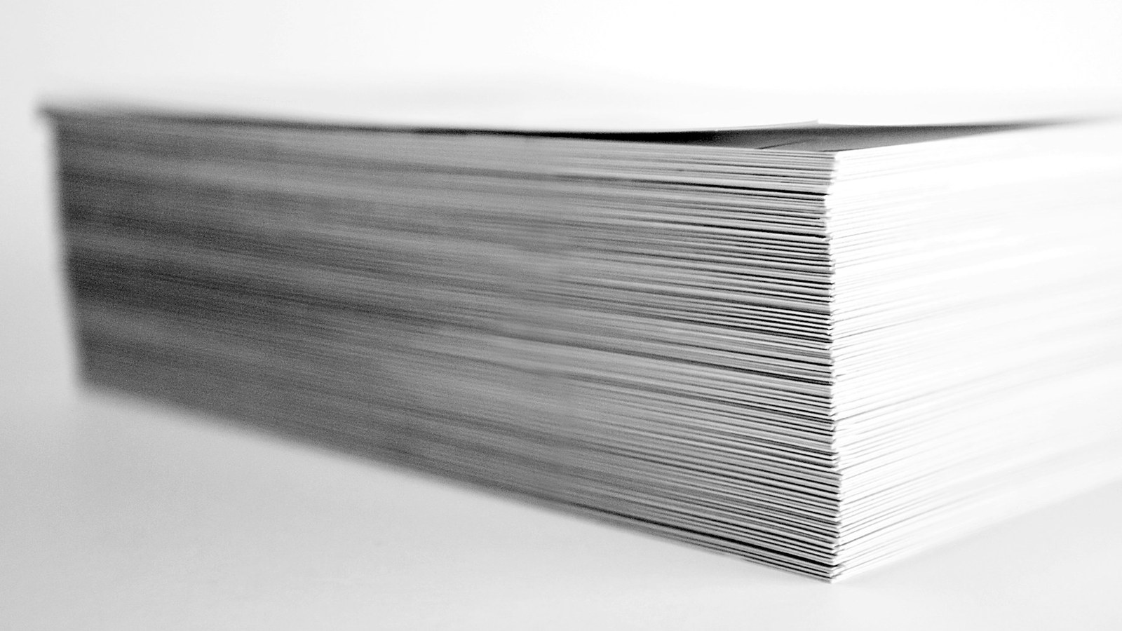 Close-up stack of printed paper showing print volume and production choices